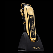 Gold Wahl hair clipper on a black charging stand with a black background Primos Barber Supplys