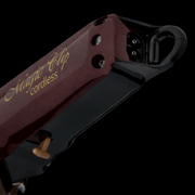 Close-up of a red and black electric clipper with 'Magic Clip cordless' branding on a dark background.