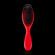 Red Stylecraft brush with black bristles on a black background laying down Primos Barber Supply