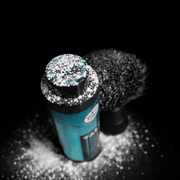 Top of Rolda Talc Bottle next to neck duster with powder on top of cap on a black background 