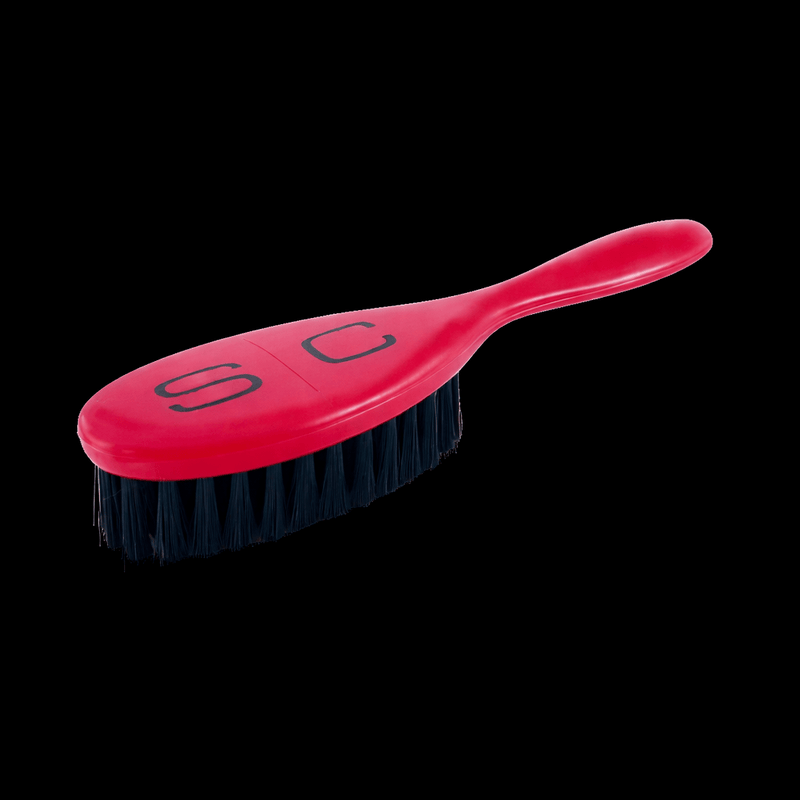 Red brush with black bristles on a white background