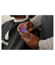 Andis Master Dual Magnet Comb Set – purple comb and clipper held by barber