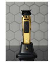 Gold and black Andis hair trimmer on a stand against a hexagonal patterned background