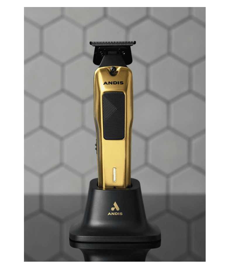 Gold and black Andis hair trimmer on a stand against a hexagonal patterned background