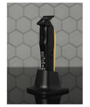 Black and gold hair trimmer on a stand with a geometric patterned background