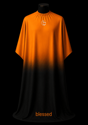 Blessed Capes Cinder barber cape featuring a bold orange to black gradient design, lightweight water-resistant material, and full professional coverage for barbers and stylists.