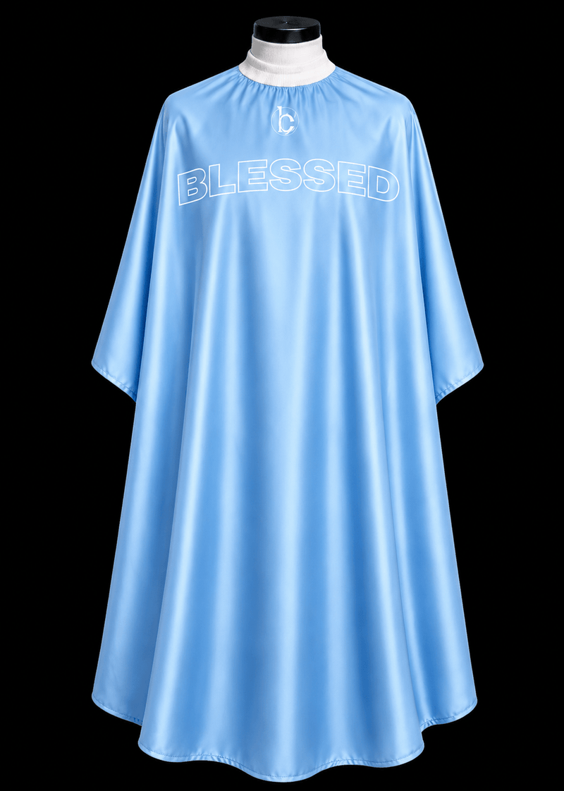 Blessed Capes Powder barber cape in a soft powder blue color featuring lightweight water-resistant material and full professional coverage for barbers and stylists.