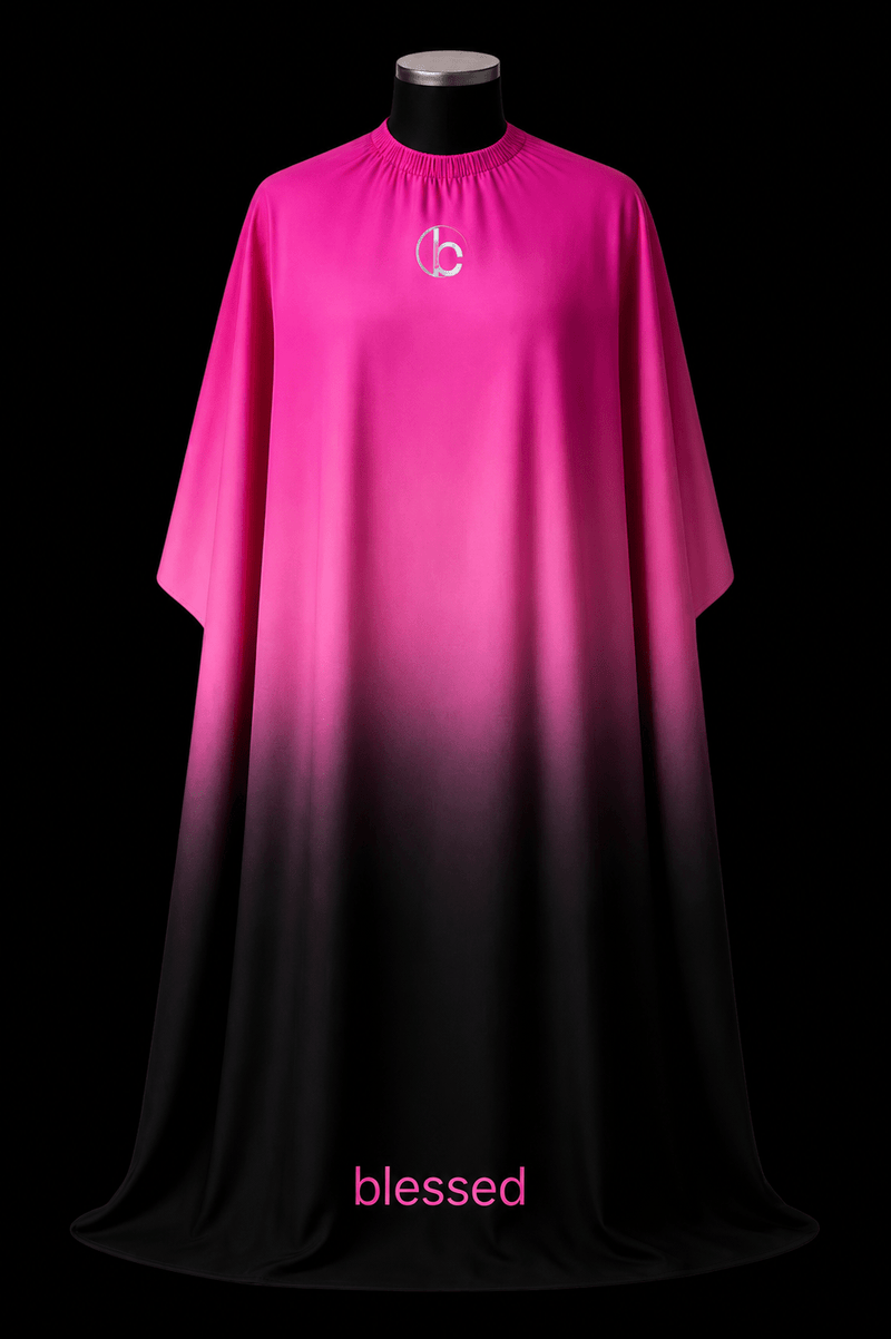 Blessed Capes Velour barber cape featuring a pink to black gradient design, lightweight comfort, water-resistant material, and full professional coverage for barbers and stylists.