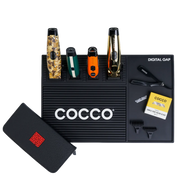 COCCO barber station mat with professional clippers, trimmers, razor, combs, and barber tools organized on a workstation.