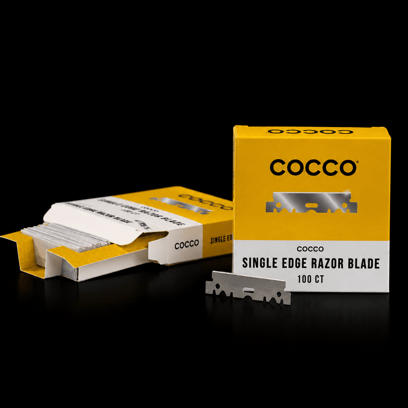 Cocco single edge razor blade pack with a yellow and white box, an opened pack showing the blades inside, and one loose silver razor blade on a black background.