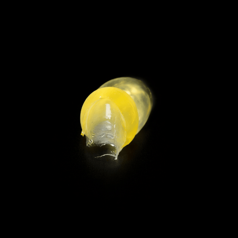 Yellow jelly like smear of the pomade on a black background