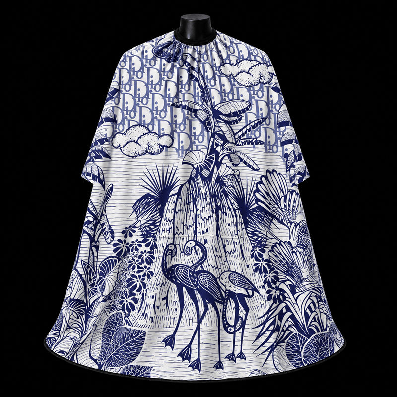 Blue Dior Paradise Barber Cape - front-facing view showing the all-over toile print with tropical birds and palm leaves in blue on a white lightweight water-resistant polyester cape