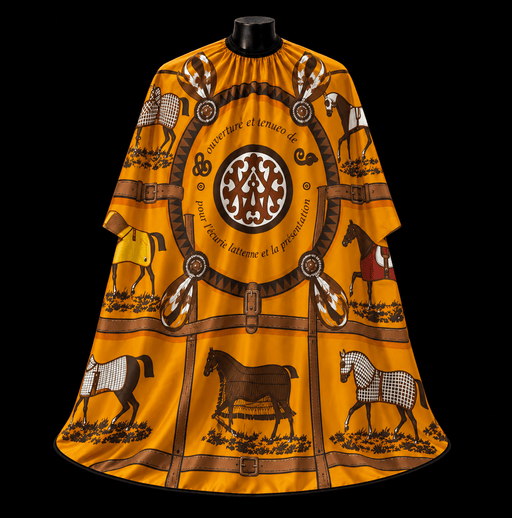 Hermes Orange Barber Cape - front-facing view showing the equestrian toile print with illustrated horses and a central medallion on a golden-orange lightweight water-resistant polyester cape