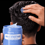 Person applying hair styling gel to their hair with a jar of Immortal Mega Structure Styling Gel.