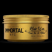 Gold jar of Immortal NYC hair wax on a black background