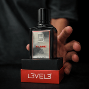 Bottle of Level 3 Flame perfume held by a hand with a black background