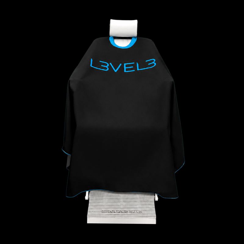 L3VEL3 Professional Rubber Neck Cutting Cape in black with blue trim, draped over a barber chair