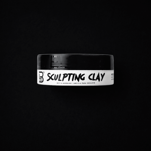 Jar of sculpting clay with a black lid on a black background