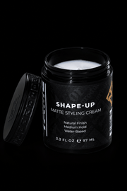 Black jar of 'Shape-Up' matte styling cream on a black background