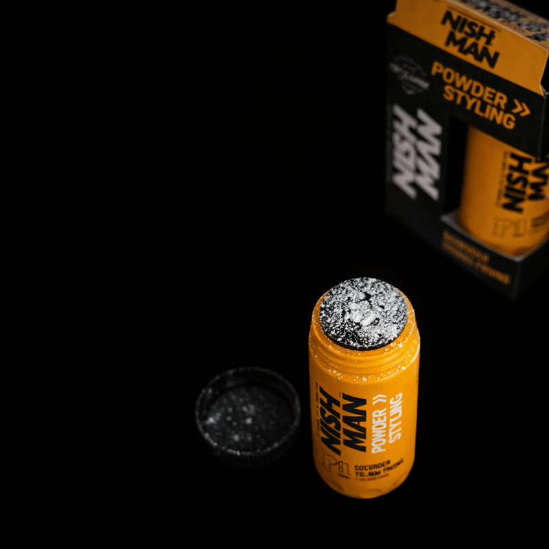 Orange bottle with white powder showing  on top of container with 'Nish Man' label amd package on a black background