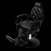 Primos Studio Barber Chair - all-black vintage barbershop chair with button-tufted backrest and filigree side panels, elevated angle