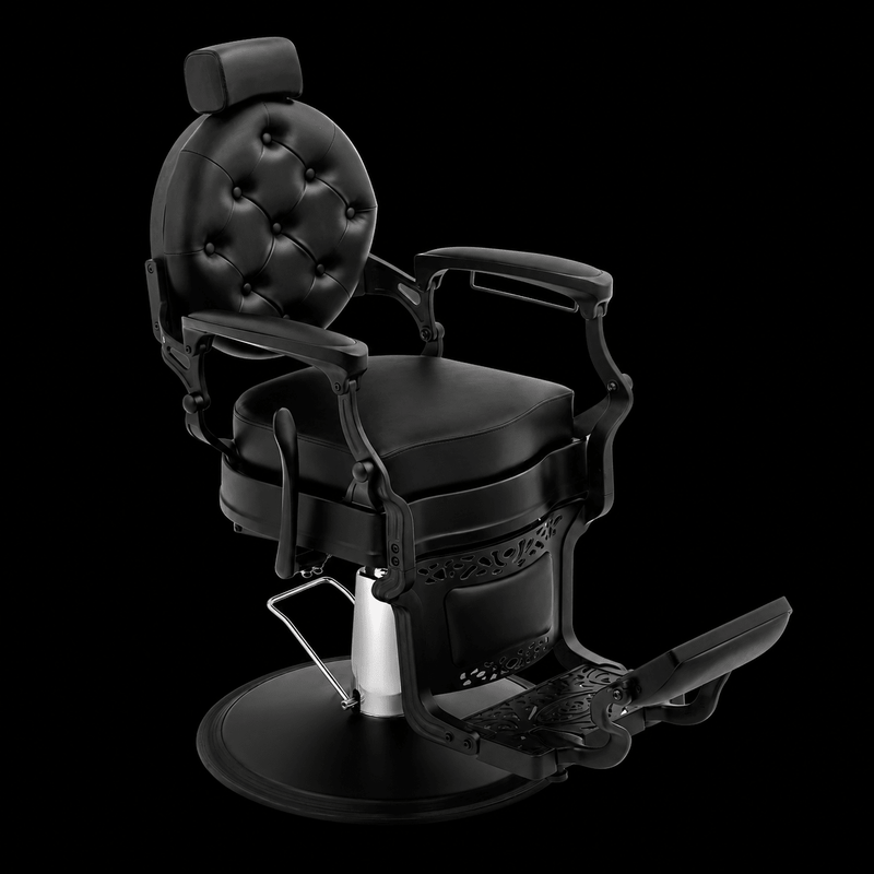 Primos Studio Barber Chair - all-black vintage hydraulic barber chair with tufted backrest and ornate filigree base, front view