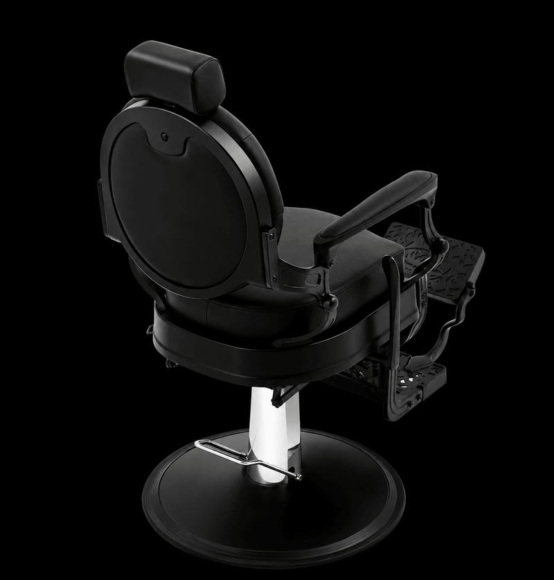 Primos Studio Barber Chair - rear view showing smooth oval backrest and ornate filigree footrest in all-black finish