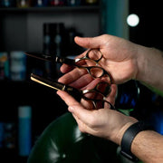 Professional barber using Rolda Gold 6 Inch Left Handed Shear Set for precision hair cutting and blending