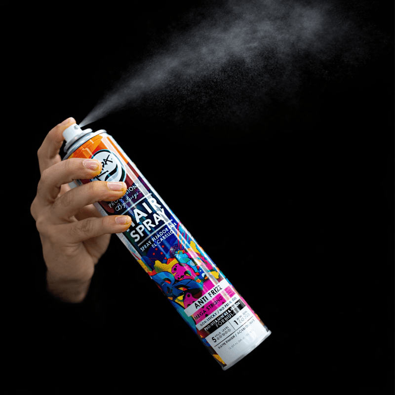Hand holding a hair spray can with colorful label against a black background. Primos Barber Supply