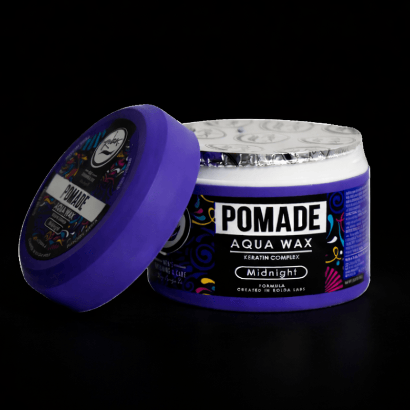 Purple jar of pomade with open lid slanted on the side, with a black background. Primos Barber Supply