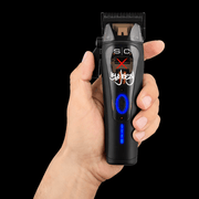 SC Pro x 360 Jeezy professional hair clipper held in hand with illuminated power button. Primos Barber Supply