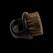 Boar bristle brush side view on a black background.