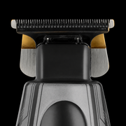 Close-up of the StyleCraft x 3Versince trimmer blade head, gold titanium fixed blade and black cutter on a black background