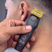 Barber using the StyleCraft x 3Versince trimmer to line up the hairline behind a client's ear