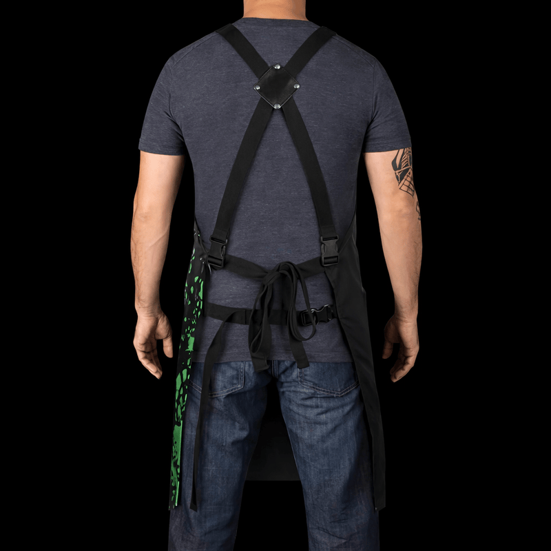 Person wearing a dark blue t-shirt with suspenders and jeans on a black background