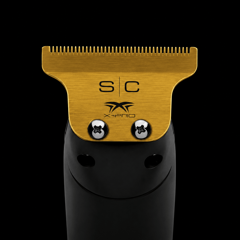 Hair trimmer head with gold top and black body on a black background