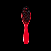 Red hairbrush with black bristles on a black background