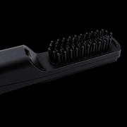 Black hair straightening brush on a black background