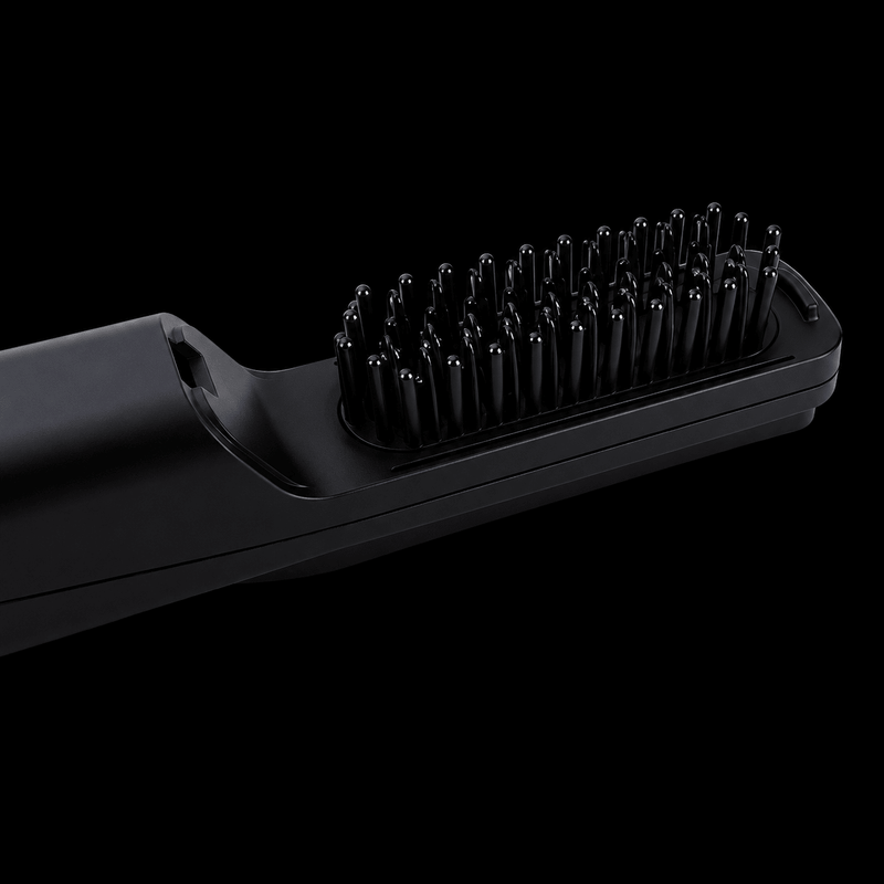 Black hair straightening brush on a black background