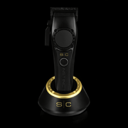 Black and gold hair trimmer on a black background