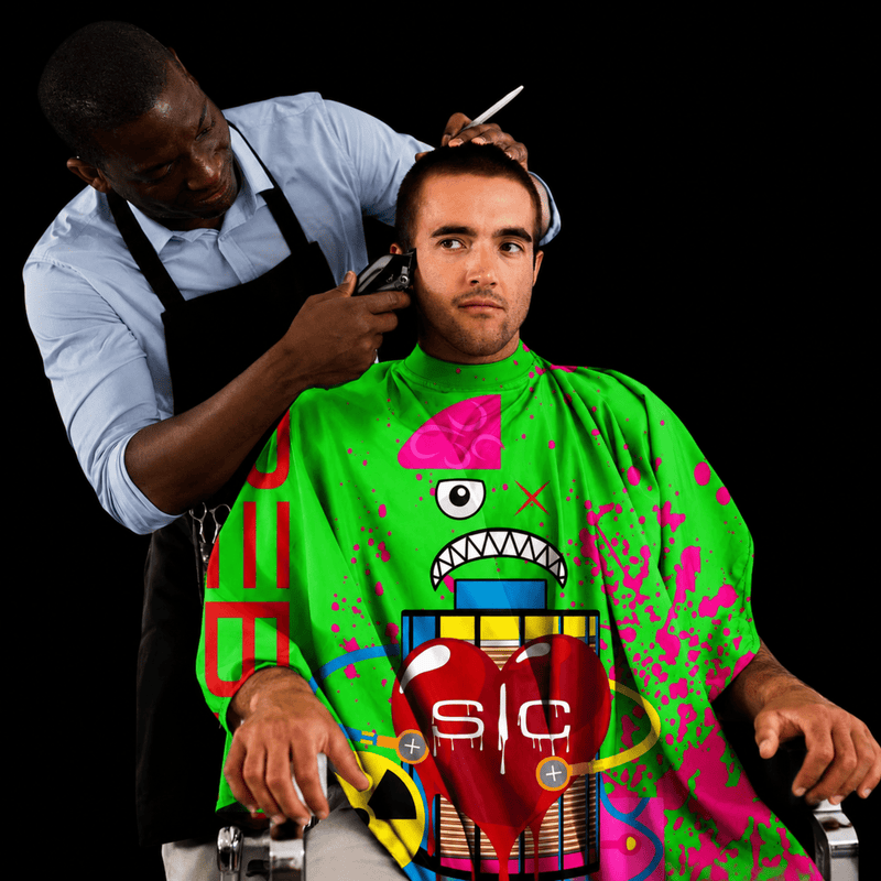 StyleCraft Radioactive Green Barber Cape in use during haircut on black background for Primos Barber Supply