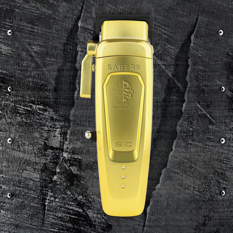 Gold electric shaver with 'Saber II' branding on a textured black background