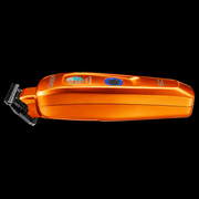 StyleCraft Saber orange trimmer lying flat in side profile showing slim metal body and T-blade on black background