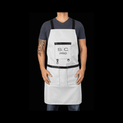 Person wearing a white apron with black accents on a black background